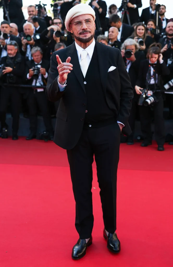 John Travolta Cannes 2026 Beret Look — The Viral Fashion Moment With the Most Heartwarming Story Behind It John Travolta navy beret Cannes 3